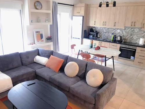 a living room with a gray couch and a table at Faliro Athens fully equipped sea view apartment 200m to beach in Athens