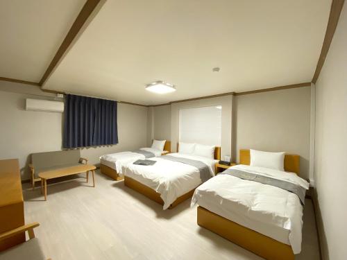 a hospital room with two beds and a table at Suanbo Hot Spring Healing Hotel in Chungju