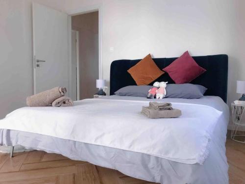 a large white bed with two stuffed animals on it at Faliro Athens fully equipped sea view apartment 200m to beach in Athens