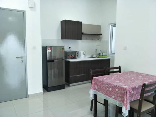 a kitchen with a table and a kitchen with a refrigerator at Mesahill Nilai 2 Room Condo - Fast wifi, Amazing Pool & TV in Nilai