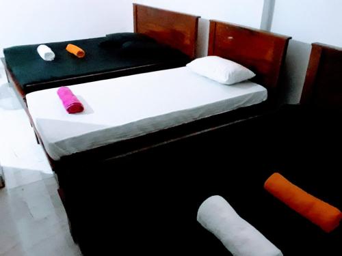 a small bed with two pillows on top of it at Black And White Kandy Guest House 01 in Kandy