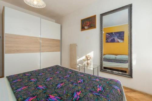 Schlafzimmer mit einem Bett und einem Spiegel in der Unterkunft Apartment Lili-with paddling pool in Umag