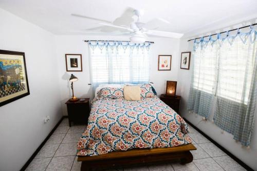 a bedroom with a bed and a ceiling fan at Toda la casa: 3 dormitorios, 4 baños y 1 futón. in Arecibo