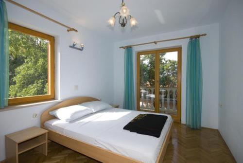 ein Schlafzimmer mit einem großen Bett und einem Fenster in der Unterkunft Apartments Luka - free parking in Novi Vinodolski