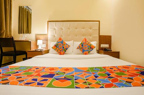 a bedroom with a large bed with a colorful bedspread at FabExpress Wynd in Mumbai