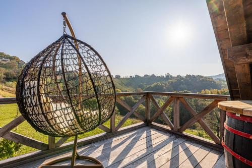 uma gaiola de pássaros sentada em cima de uma varanda em Vineyard Cottage Grajska Kašča - Happy Rentals em Mirna