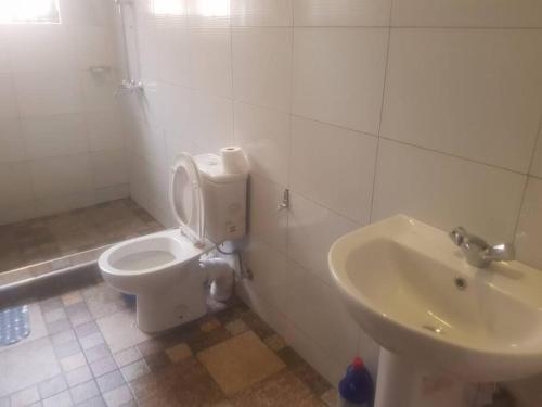 bagno con servizi igienici e lavandino di Cheerful 3 Bedroom house with ample parking space. a Kampala