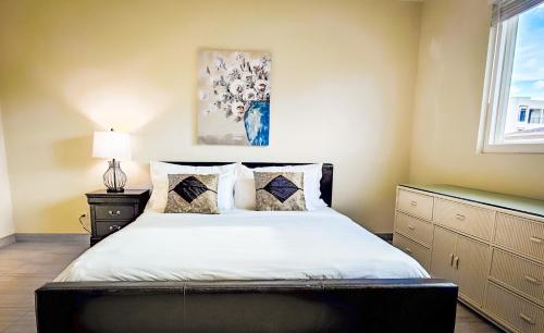 a bedroom with a bed with white sheets and a window at Tumon Isa 16 Condo in Tamuning