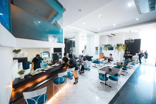 a restaurant with people sitting at tables and a counter at Hotel Pier Cuatro in Cebu City