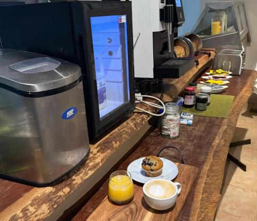 Un mostrador con una bebida y un muffin en un plato. en Sinclairs Country Retreat - Adults Only, en Conjola