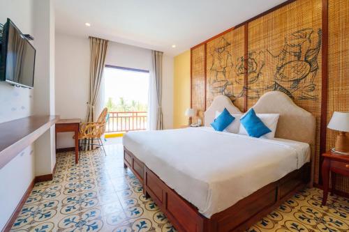 a hotel room with a large bed and a television at ZEN RETREAT HOI AN in Hoi An