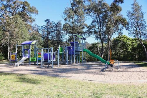 un parque con parque infantil con tobogán en Totally Beachin! - walking distance to the beach, en Eden