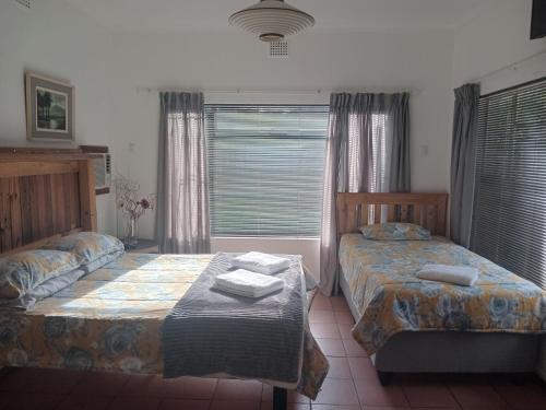 a bedroom with two beds and a window at Royal Karoo Cottage in Beaufort West