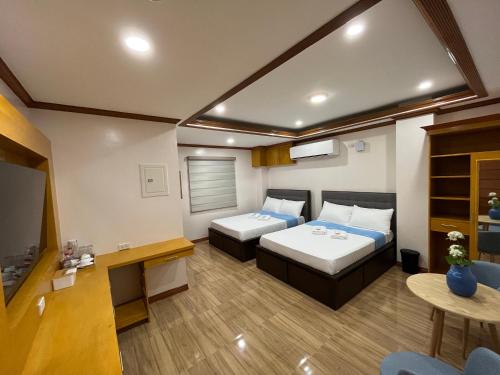 Cette chambre comprend deux lits et une télévision. dans l'établissement The Legacy Hotel, à Tayabas