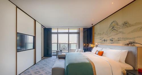 a hotel room with a bed and a large window at JiuTai Hotel Hangzhou in Hangzhou
