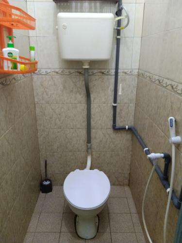 a small bathroom with a toilet in a shower at Ammar Homestay Tok Bali in Kampong Ayer Tawar