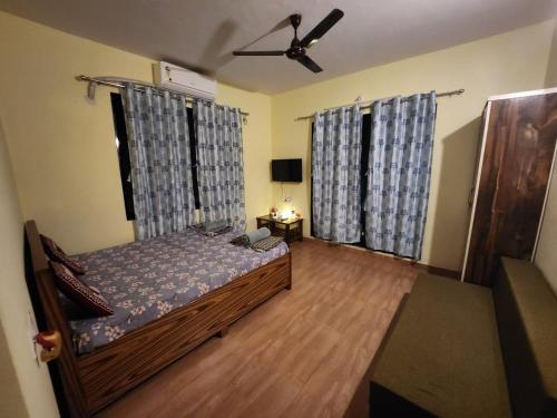 a bedroom with a bed and a ceiling fan at Bhumi Holiday Home in Alibaug