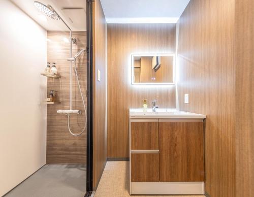 a bathroom with a sink and a shower at Apartment Hotel 11 Shinsaibashi II in Osaka