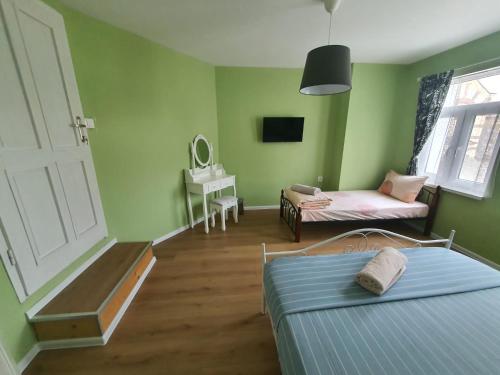 a bedroom with green walls and a bed and a table at HANCHO - OLD TOWN CENTER PLOVDIV in Plovdiv