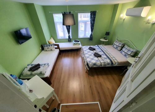 a living room with two beds and green walls at HANCHO - OLD TOWN CENTER PLOVDIV in Plovdiv