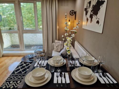 a dining room table with plates and silverware on it at Paddington in London