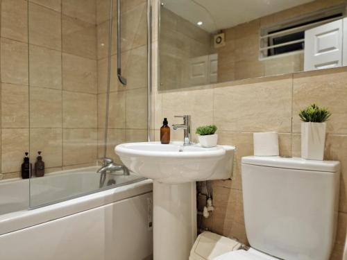 a bathroom with a sink and a toilet and a bath tub at Paddington in London