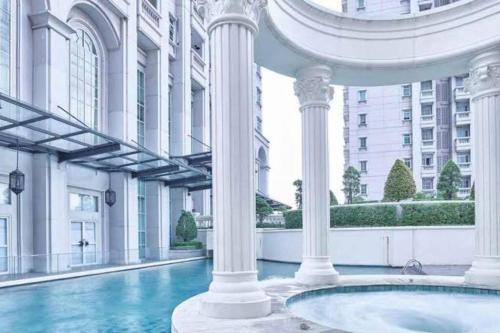 a large building with columns and a swimming pool at Lovely 3-Bedroom rental unit in Jakarta
