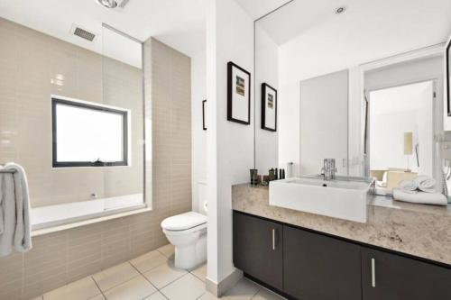 a white bathroom with a sink and a toilet at Scenic Golf & Spring 1BR Getaway in Fingal