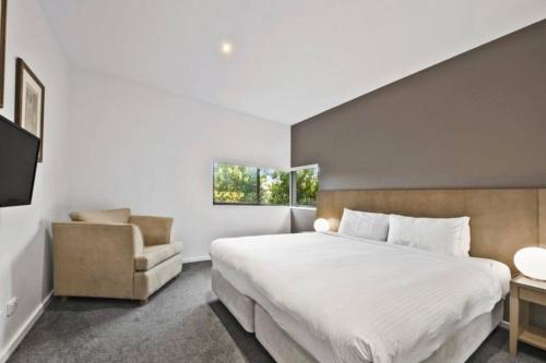 a bedroom with a large bed and a chair at Scenic Golf & Spring 1BR Getaway in Fingal