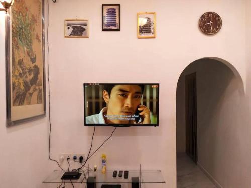 Elle comprend une télévision à écran plat suspendue au mur. dans l'établissement Homestay Dahlia, à Teluk Intan