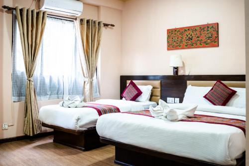 ein Hotelzimmer mit 2 Betten und einem Fenster in der Unterkunft Hotel Namtso in Kathmandu