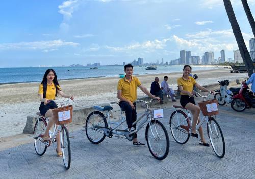 a group of three people riding bikes on the beach at Sontra Sea Hotel in Danang