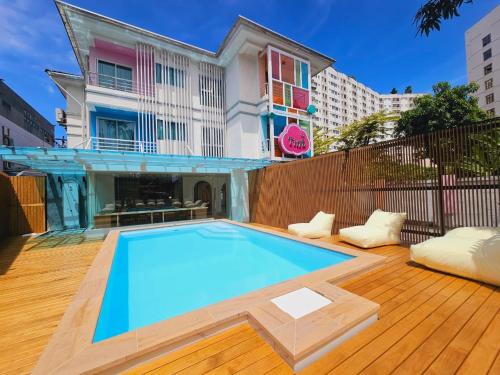 a swimming pool in front of a house at The Tint At Phuket Town - SHA Plus in Phuket