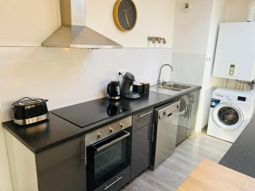 a kitchen with a sink and a stove top oven at Harmonieux/Bezannes/Pkg Privé in Bezannes-les-Reims