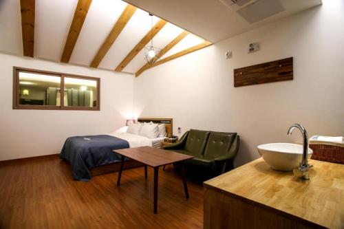Habitación con baño con cama y lavabo. en Hotel The Jaja, en Gongju