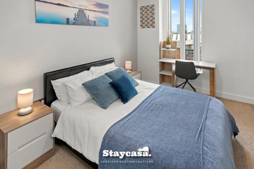 a bedroom with a bed and a desk with a chair at Spectacular Apartment Balcony View In City Centre in Manchester