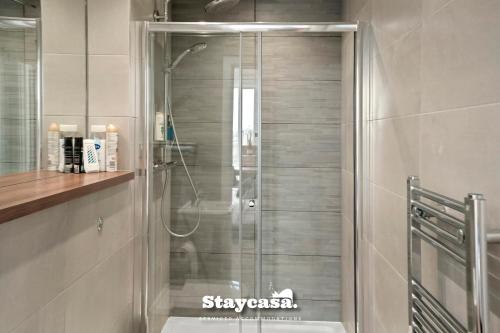 a shower with a glass door in a bathroom at Spectacular Apartment Balcony View In City Centre in Manchester