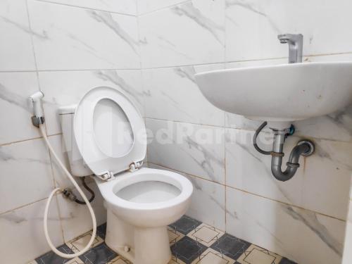 a bathroom with a toilet and a sink at Ada Guest House Medan Redpartner in Medan