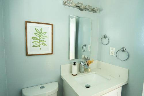 a bathroom with a sink and a toilet and a mirror at Retreat Minutes To LAX, Manhattan/ Redondo Beach in Torrance