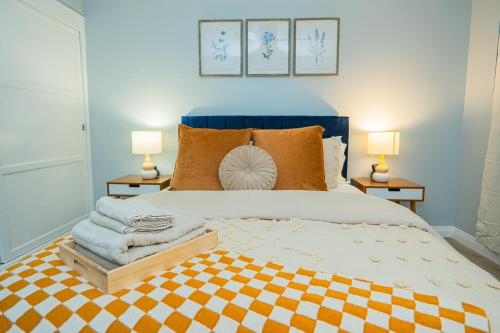 a bedroom with a bed with a blue headboard and two lamps at Retreat Minutes To LAX, Manhattan/ Redondo Beach in Torrance