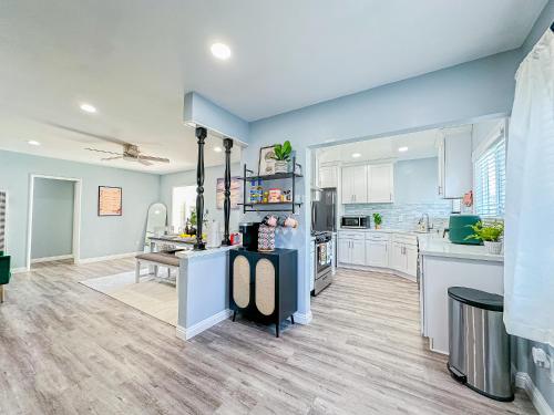 a large kitchen with blue walls and white cabinets at Retreat Minutes To LAX, Manhattan/ Redondo Beach in Torrance