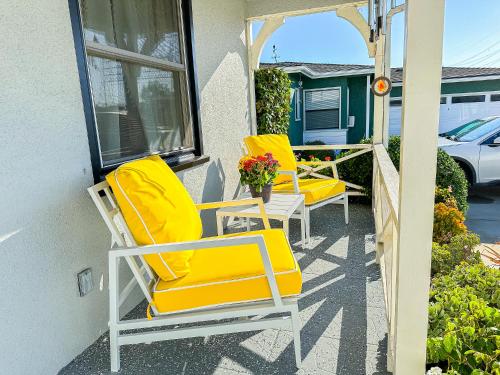 a pair of yellow chairs sitting on a porch at Retreat Minutes To LAX, Manhattan/ Redondo Beach in Torrance