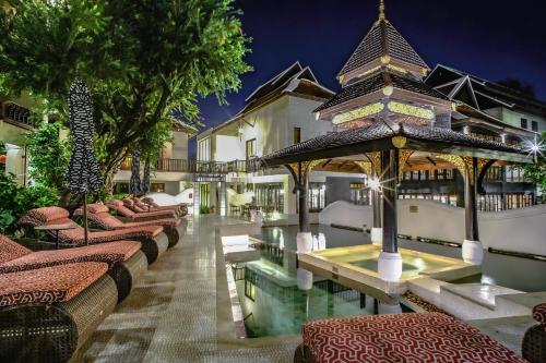 a hotel with a swimming pool and a resort at Puripunn Hideaway in Chiang Mai