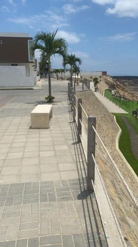 a bench on a sidewalk next to a fence at Startfish house in Manta