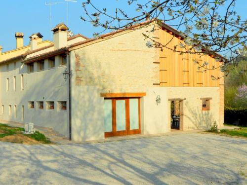 a large white building with a garage at Modern Farmhouse in Pagnano Italy near Forest in Asolo