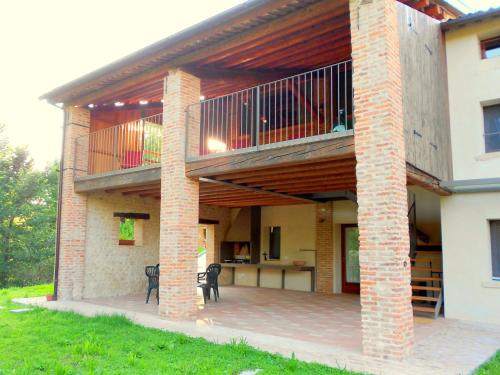 a large patio with a balcony on a house at Modern Farmhouse in Pagnano Italy near Forest in Asolo