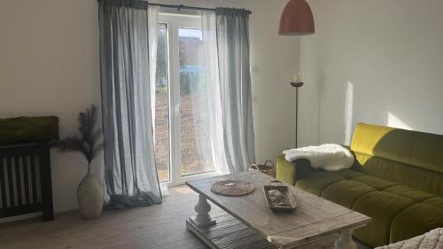 ein Wohnzimmer mit einem grünen Sofa und einem Couchtisch in der Unterkunft Erholung pur für die ganze Familie in Ribnitz-Damgarten