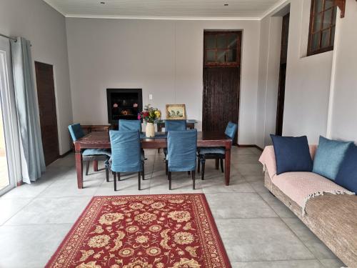 a living room with a table and chairs and a couch at Geelkop Plaashuis in Keimoes