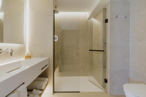 a bathroom with a shower and a toilet and a sink at Golden Coast Beach Hotel in Protaras