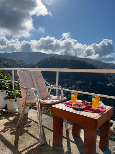 una silla y una mesa en un balcón con vistas en Tropical House, en Ribeira Brava